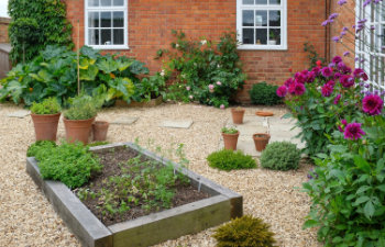 oak sleeper raised beds in a hard landscaped courtyard garden with gravel